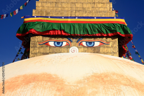 Boudhanath Stupa decorated with colorful Buddhist prayer flags against a deep blue sky in Kathmandu, Nepal
