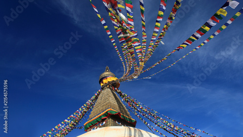 Boudhanath Stupa decorated with colorful Buddhist prayer flags against a deep blue sky in Kathmandu, Nepal