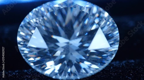 Brilliant diamond gemstone reflecting light on black velvet surface, showcasing intricate facets and clarity under bright illumination in a close-up view
