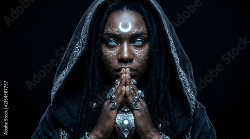 Mysterious woman with a crescent moon symbol on her forehead wearing a dark hooded cloak and ornate jewelry