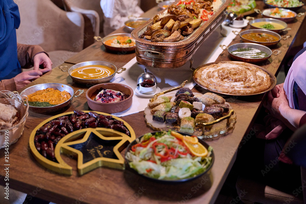 Obraz premium Gathering of family and friends at a traditional iftar feast during Ramadan in a cozy dining space