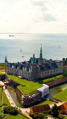 Vertical video. Helsingor, Denmark. Kronborg Castle, a Renaissance fortress with sandstone walls and copper spires, Drone footage over the Oresund Strait under bright summer sky. Drone footage, Depar