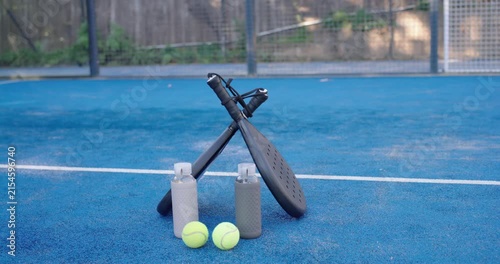 Cam is adjusting frame to steady while paddles balls bottles are staying centered on blue court