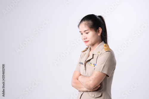 Pensive Thai teacher in government official school uniform, hand on chin, looking serious thoughtful against a white background.