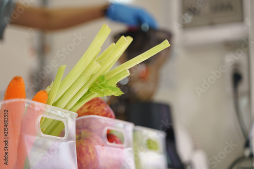 Fresh fruits and vegetables ready for juicing near a modern fruit juicer.