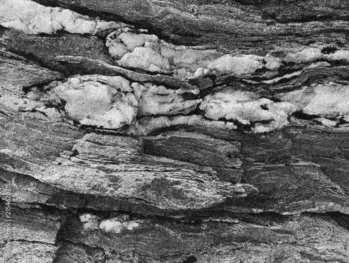 Layered Rock Surface with Snow in Crevices in Grainy Black and White Close Up