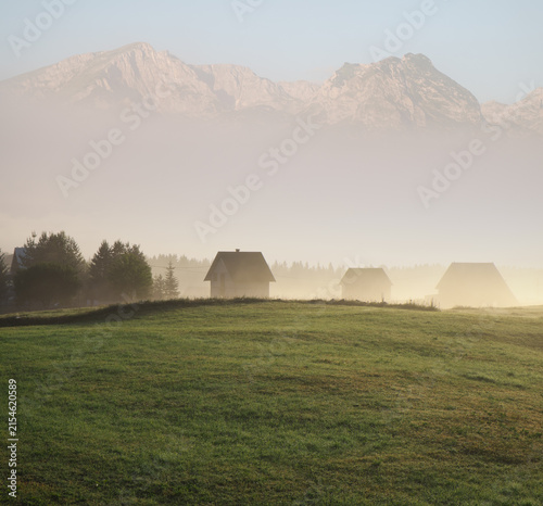 dreamy landscape with village and mountains peaks over the morning fog in Montenegro