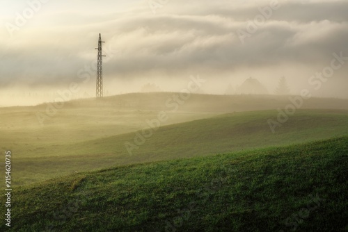 dreamy scene with morning fog and pylon of electricity in Montenegro