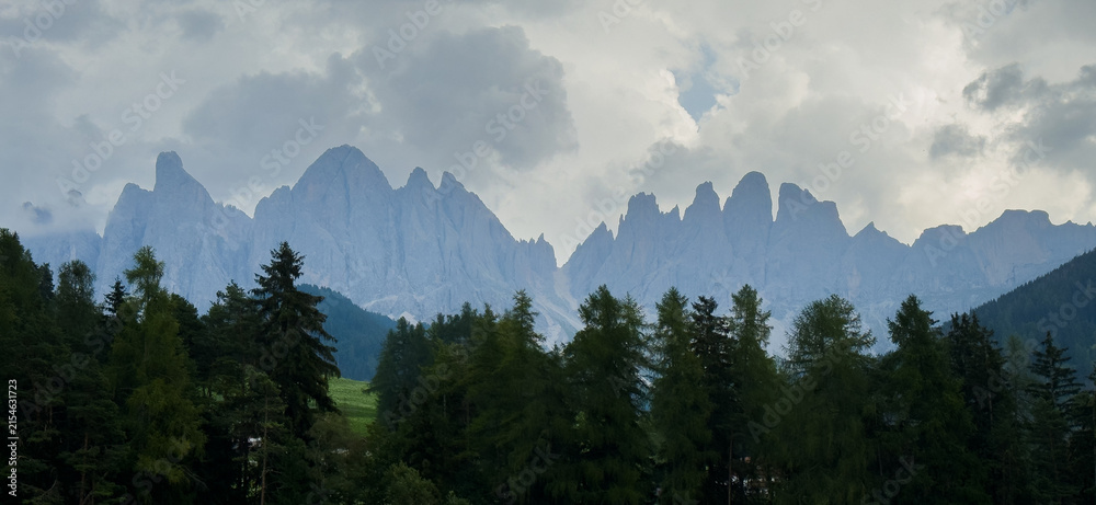 Obraz premium Majestic scenery of rough mountain ridge near grassy hills 