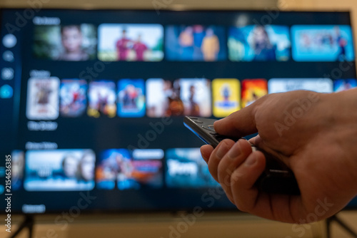 Foto Close-up of a hand holding a remote toward a screen