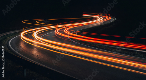 Curving road illuminated by long exposure light trails at night