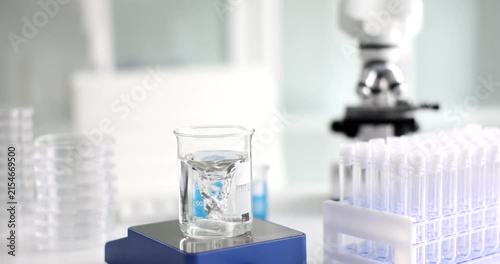 In a bright laboratory, colorful liquids swirl in a glass beaker while surrounding tools reflect the pursuit of knowledge and discovery in science.