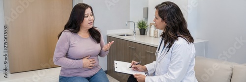 Woman discusses abdominal discomfort with doctor, GLP-1 side effects and obesity treatment consultation concept