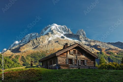 Fotografía Traditional wooden chalet of Auberint La Boerne in front of snow-capped Aiguille Verte mountain on the Tour du Mont Blanc trail, France