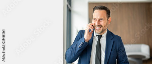 Fotografía Smiling professional businessman having a mobile phone conversation