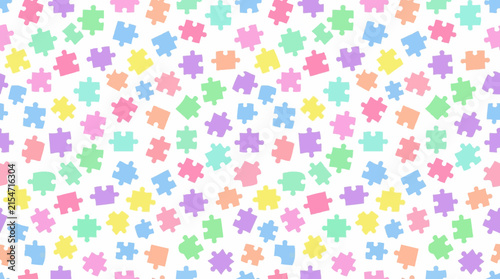 Many colorful puzzle pieces are scattered on a white background