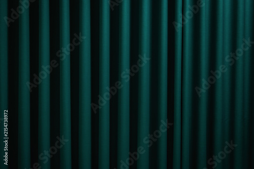 Elegant dark green fabric curtain with vertical folds for a luxury interior background