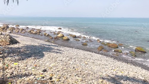 Gentle waves washing over a pebble beach on a sunny day