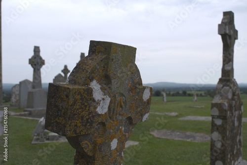 Ancient Celtic crosses standing weathered in a serene Irish landscape, symbolizing enduring cultural heritage and spiritual connection to the past for travel and education purposes.