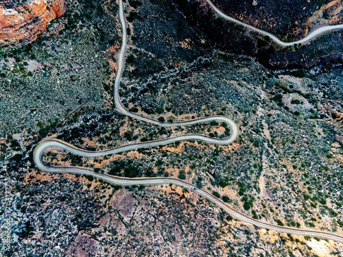 Aerial of mountain pass, dirt road winding from above