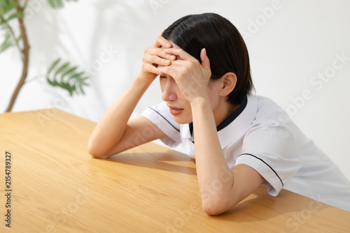 悩む白衣を着た女性