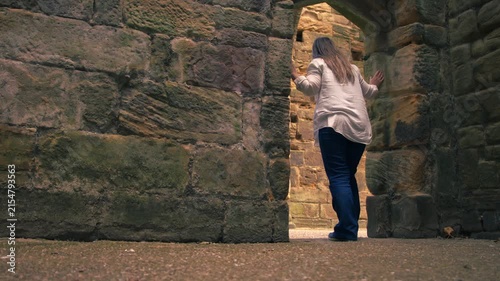 Tourist exploring ruins of old monastery archway at Monk Bretton Priory in Yorkshire