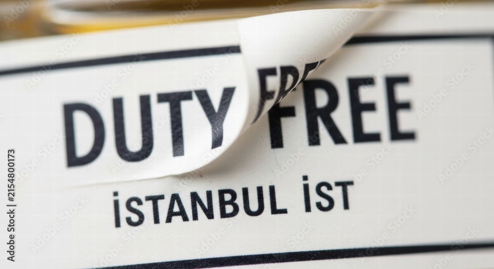 Fototapeta premium A close-up of a duty-free label with peeling paper, displaying black and white text, AI generated