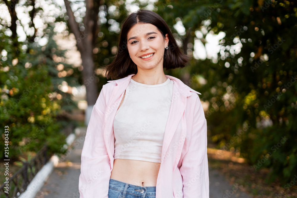 Fototapeta premium Young woman smiling outdoors enjoying nature and freedom