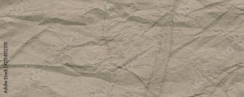 Crumbled beige paper texture background for design with soft light, seamless background of weathered material.