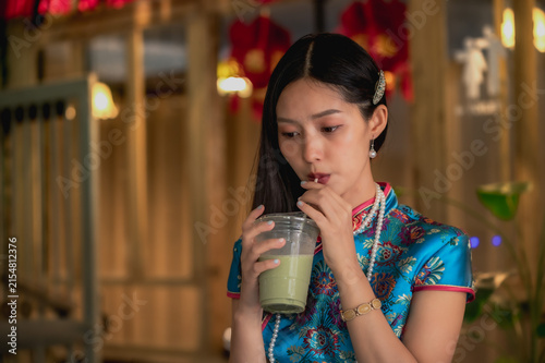 Canvas Print Young Chinese woman wearing traditional silk blue qipao and pearl necklace in vi