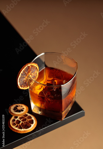 Принти на полотні Old-fashioned cocktail with ice and a dried orange slice.