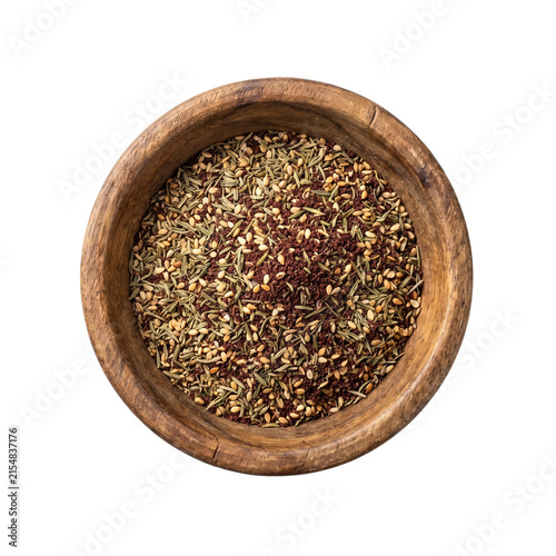 Fragrant zaatar spice blend served in a rustic wooden bowl isolated on a white background