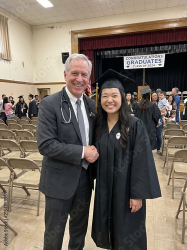 Doctor congratulating nursing graduate at commencement ceremony