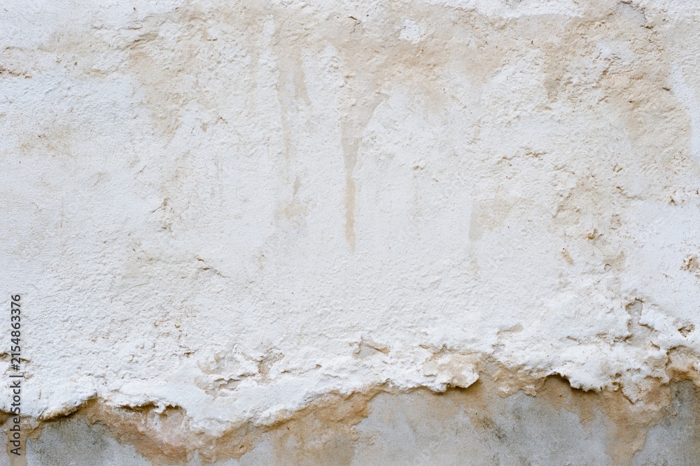 Fototapeta premium The Weathered Plaster Wall with Peeling Paint and Earthy Stains