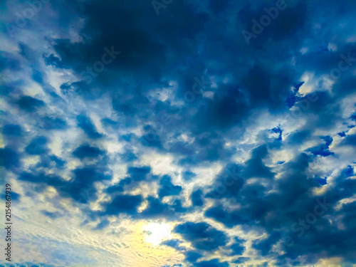 Fotografie Dramatic sky with dark storm clouds and bright sunlight breaking through, creati