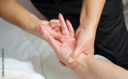 Foto Massage therapist performing a professional hand and wrist massage on a female client