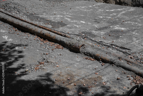 Fotografie Rusty pipes lying on construction site dirt ground
