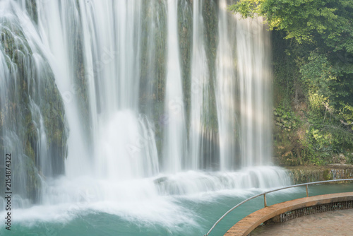 Pliva Waterfall in Jajce, Bosnia and Herzegovina surrounded by lush green forest