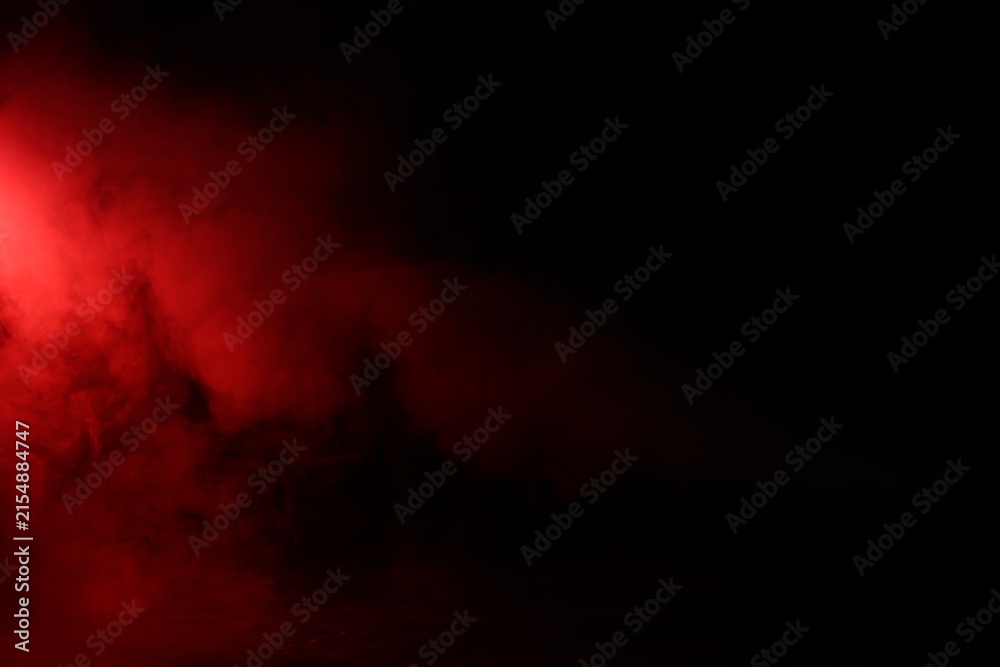 Naklejka premium Beautiful smoke in neon light on dark background, space for text