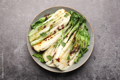 Fotografie Tasty cooked bok choy cabbages with sesame seeds and sauce served on grey table,