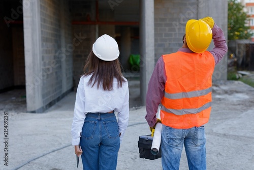 Construction workers inspecting building site progress, architect and foreman discussing project