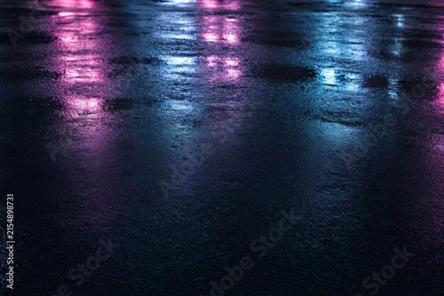 Neon streetlight reflections on glossy black pavement  
A high‑contrast image of neon streetlights reflected on glossy pavement, creating luminous streaks and soft halos.