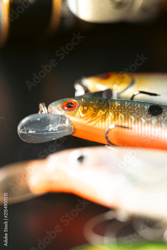 Quadro su tela Colorful fishing lures with hooks on dark background The Concept of angling and