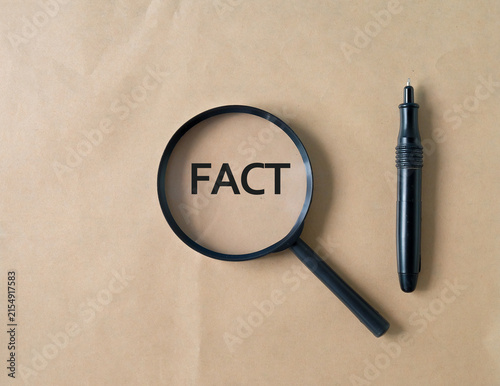 Magnifying Glass focus on word FACT on background.