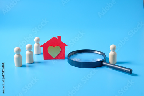 A paper house with golden heart symbol with wooden figures .