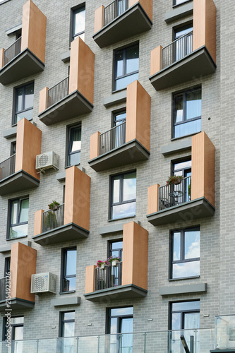 Canvas Print Modern apartment building facade featuring stylish wooden balconies and grey bri