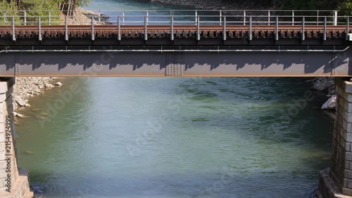 Scenic railway bridge spanning a tranquil flowing river