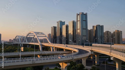 Modern city skyline with highway interchange at sunset