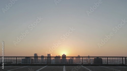 Rooftop parking lot with a city sunrise
