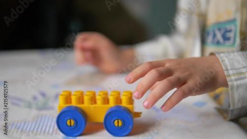Child's Hands Playing with a Plastic Building Block Toy Car